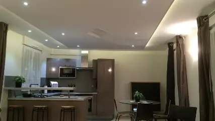 La pièce de vie avec cuisine ouverte et plafond équipé de spots et d’un éclairage indirect.